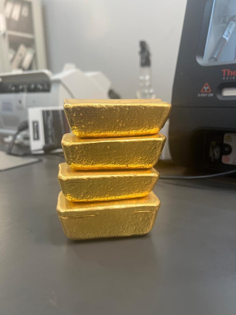 Gold bars beside Thermo Scientific XRF purity testing equipment